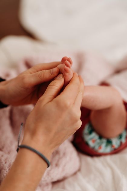Due mani adulte massaggiano il piede di un infante